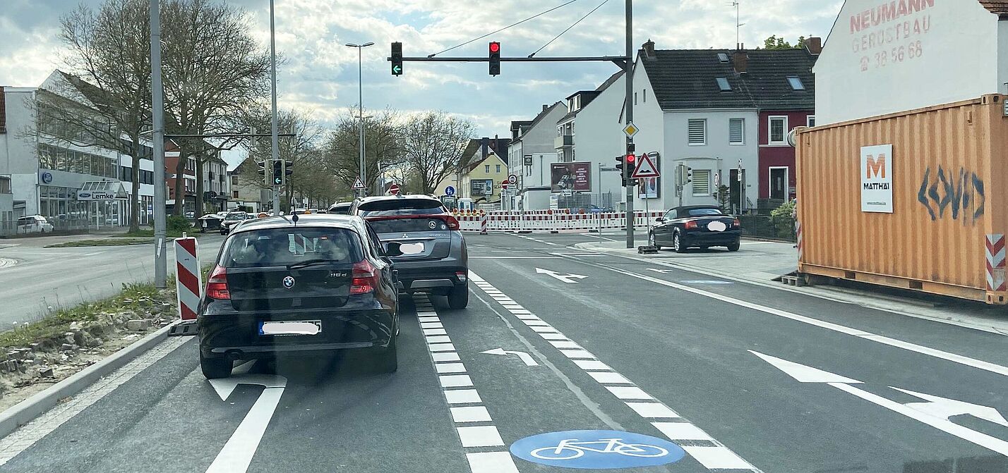 Kreuzung Osterfeuerberger Ring/Holsteiner Straße An einer Baustellensituation verdecken Autos auf dem Radfahrstreifen die Sicht auf eine wartende Radfahrerin