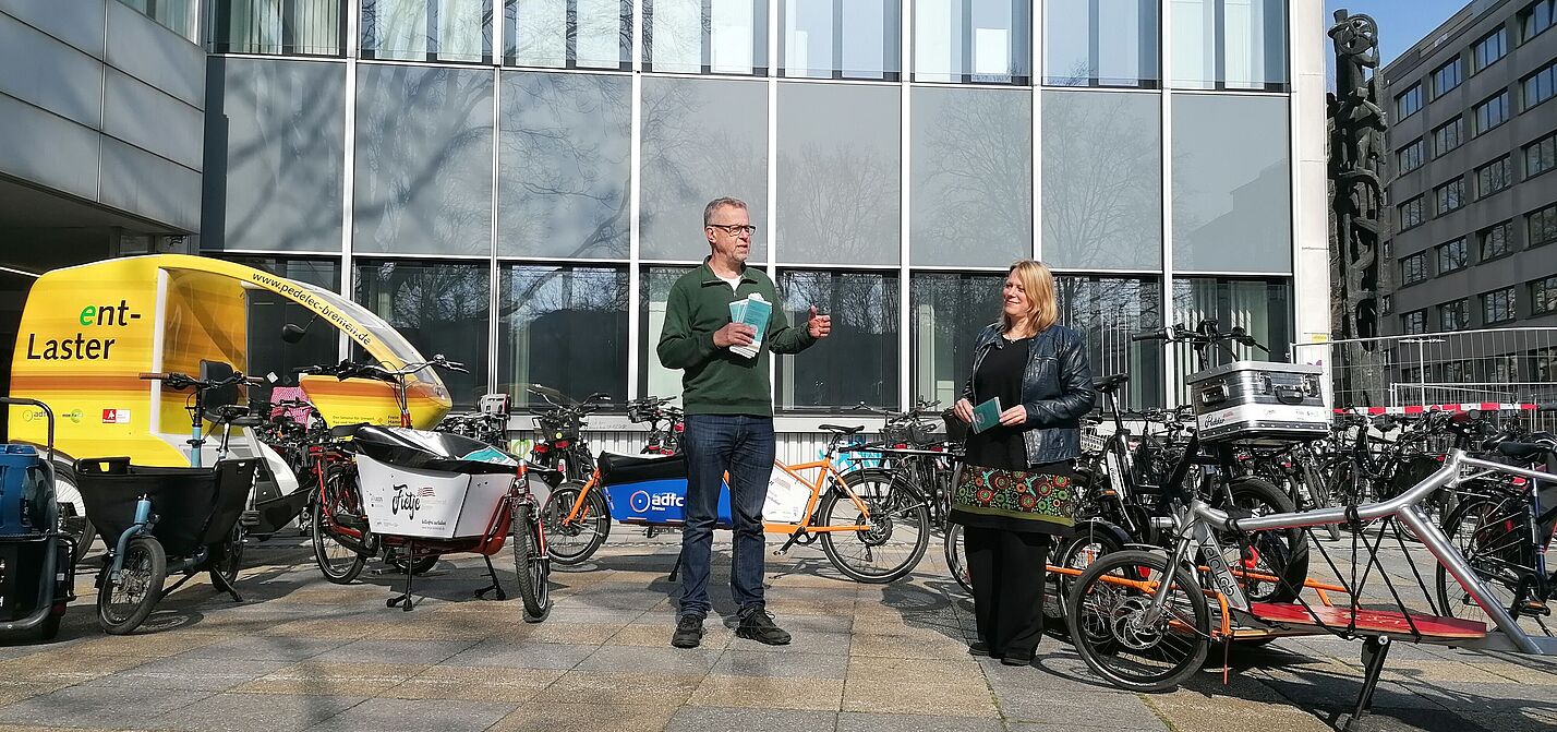 Lastenradförderung Michael Glotz-Richter und Senatorin Dr. Maike Schaefer stehen vor einer Reihe von Lastenrädern