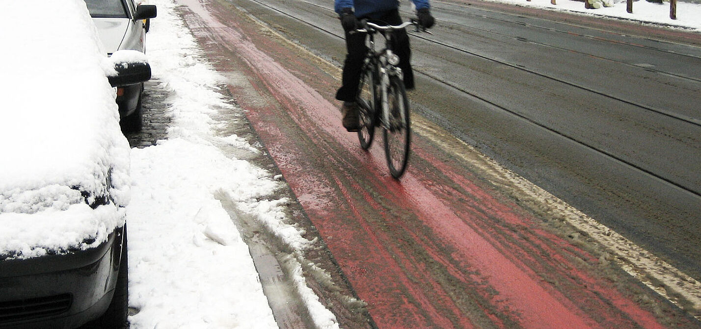 Ein leicht verschneiter Radweg.